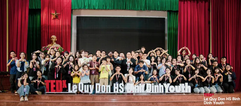 Ban tổ chức, diễn giả và tình nguyện viên TEDx chụp ảnh chung trên sân khấu, cùng tạo dáng chữ X